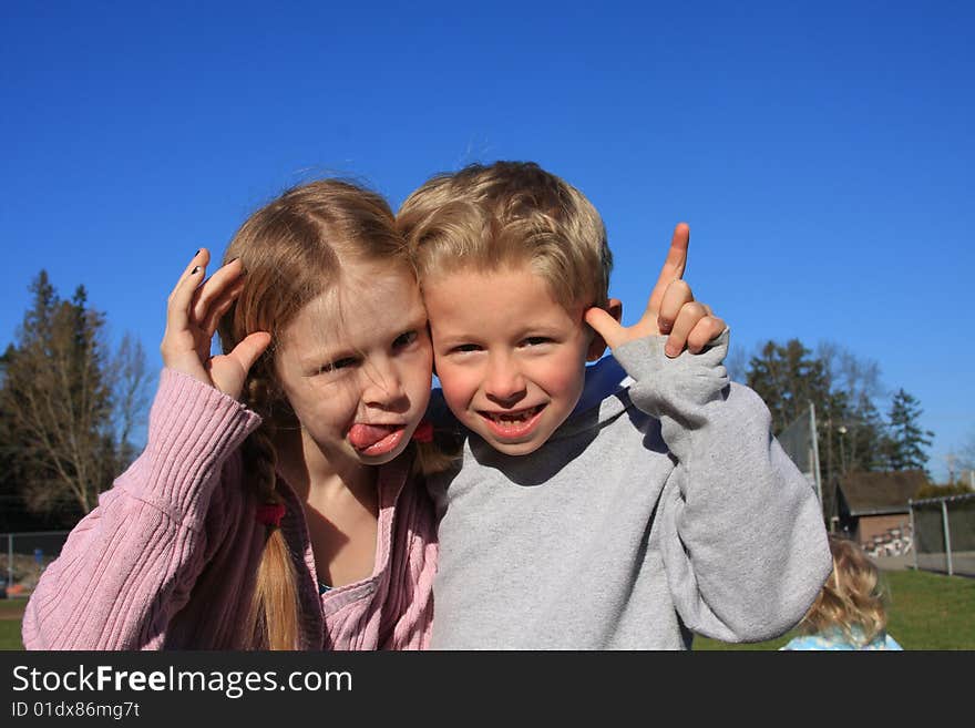 Bigger sister with little brother making a funny face at the camera. Bigger sister with little brother making a funny face at the camera