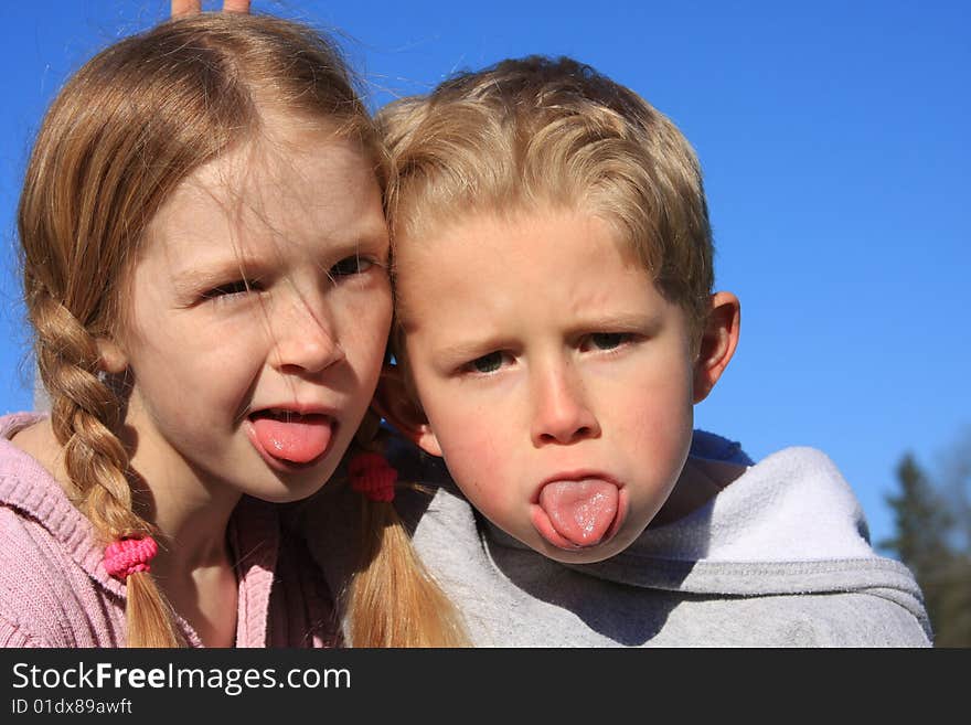 Bigger sister with little brother making a funny face at the camera. Bigger sister with little brother making a funny face at the camera