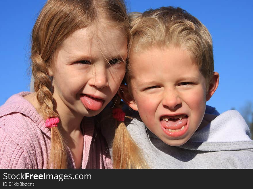 Bigger sister with little brother making a funny face at the camera. Bigger sister with little brother making a funny face at the camera