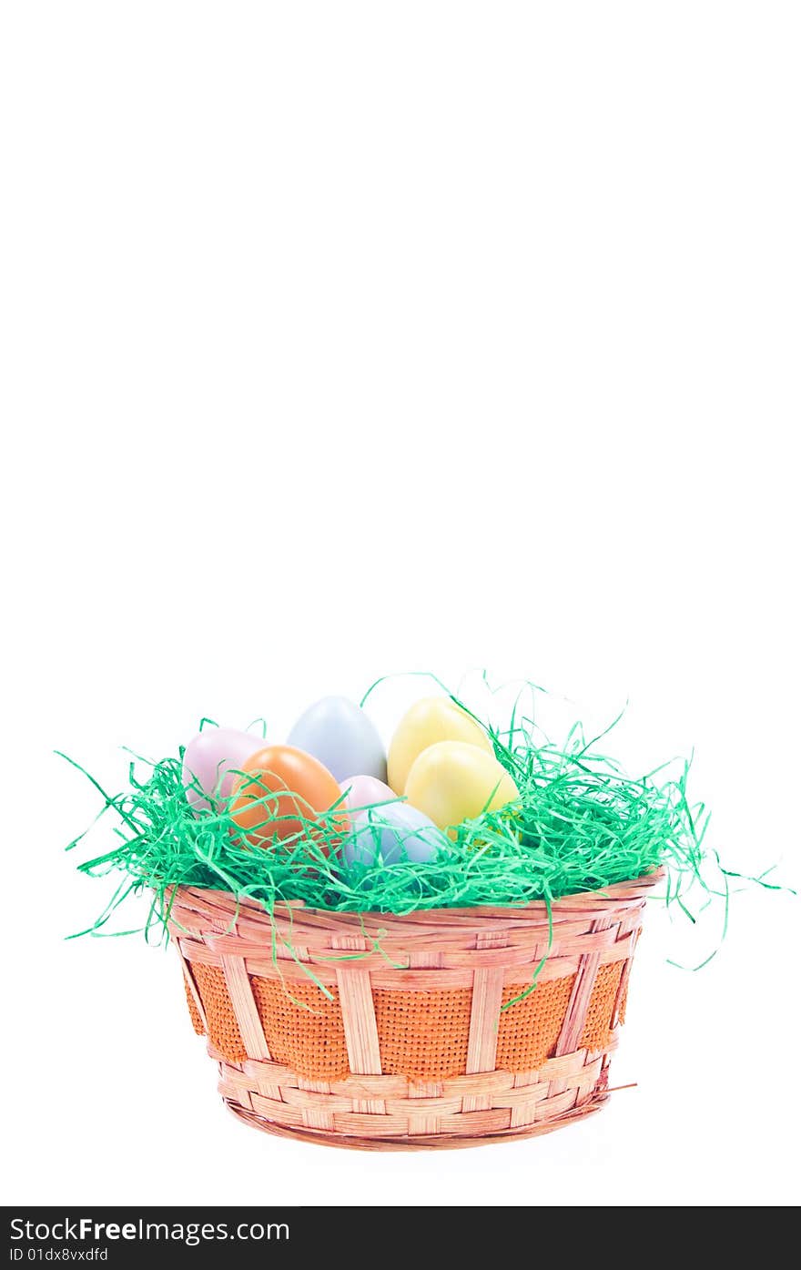 Easter basket full with coloured eggs and green grass