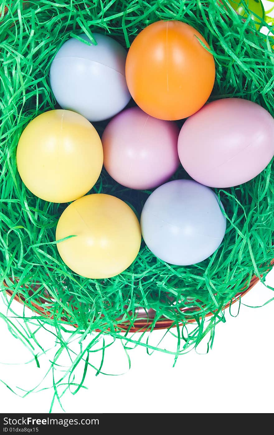 Easter basket full with coloured eggs and green grass