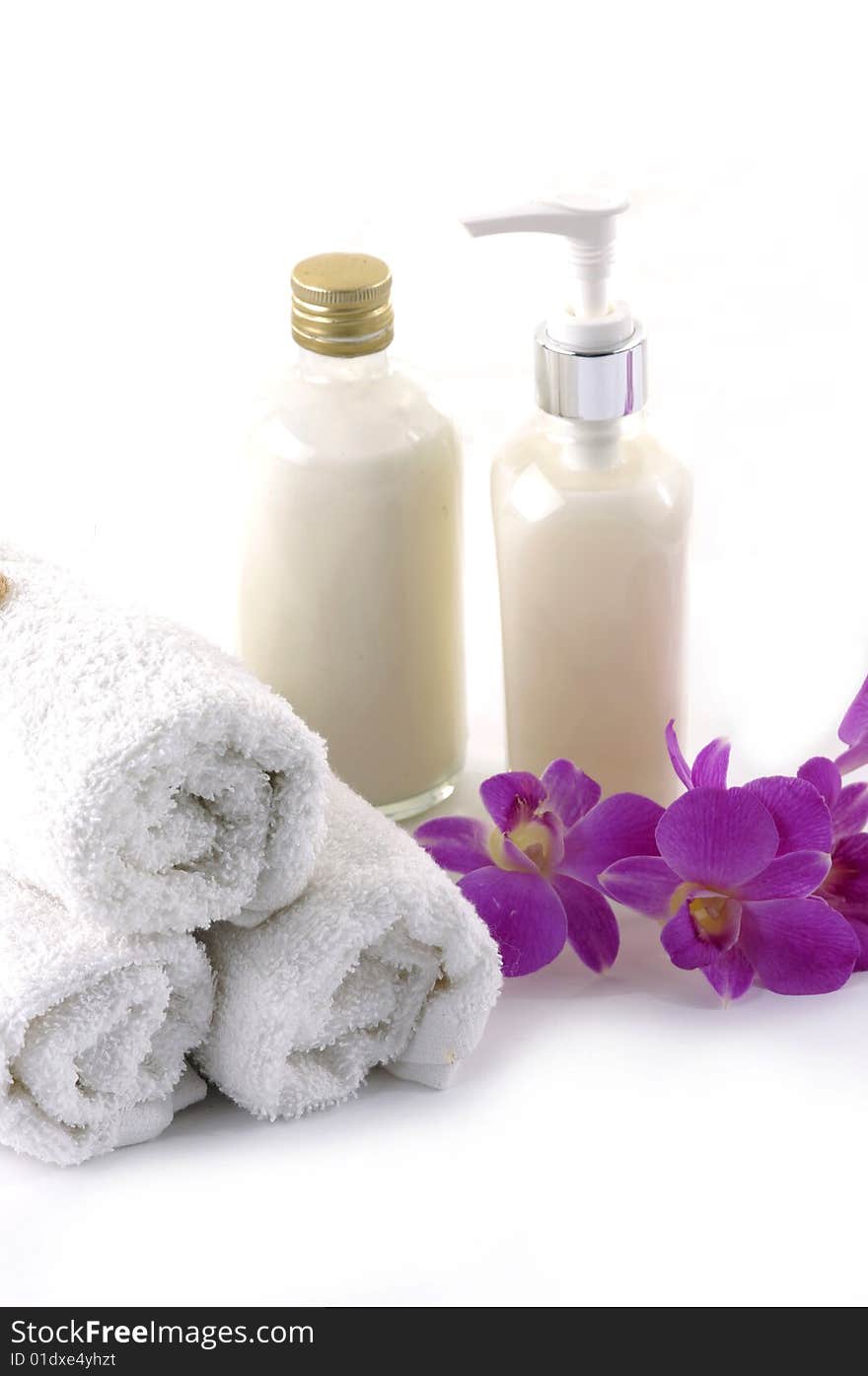 Towels, orchid and bath lotion on the white background. Towels, orchid and bath lotion on the white background