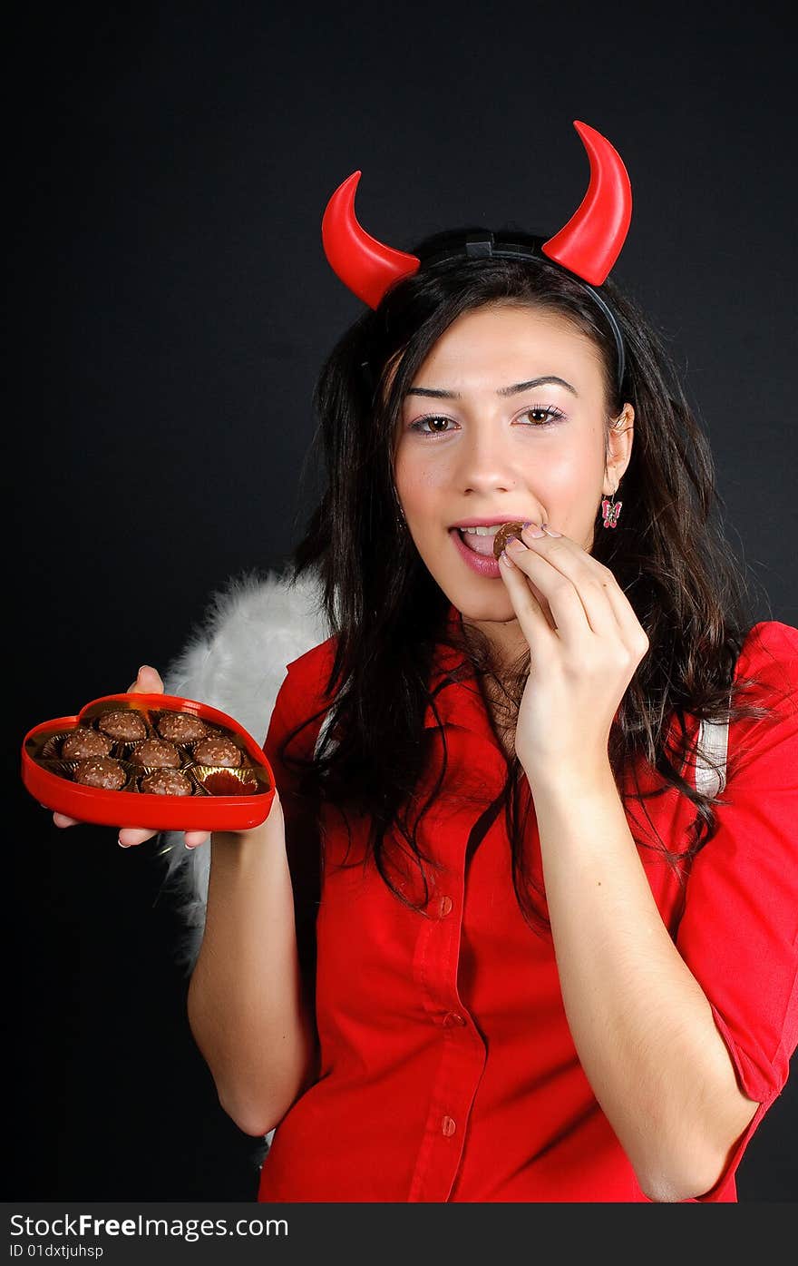 Valentine Girl eating chocolate bonbons from a heart shape box