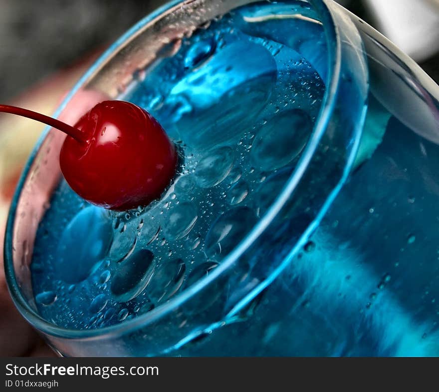 A red cherry splashing into blue water