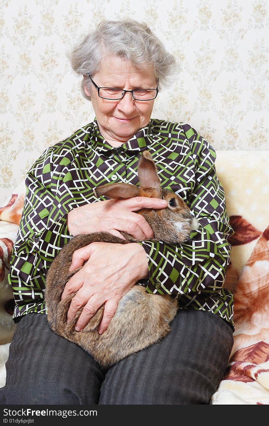 Smiling grandmother hold on hands bunny. Smiling grandmother hold on hands bunny