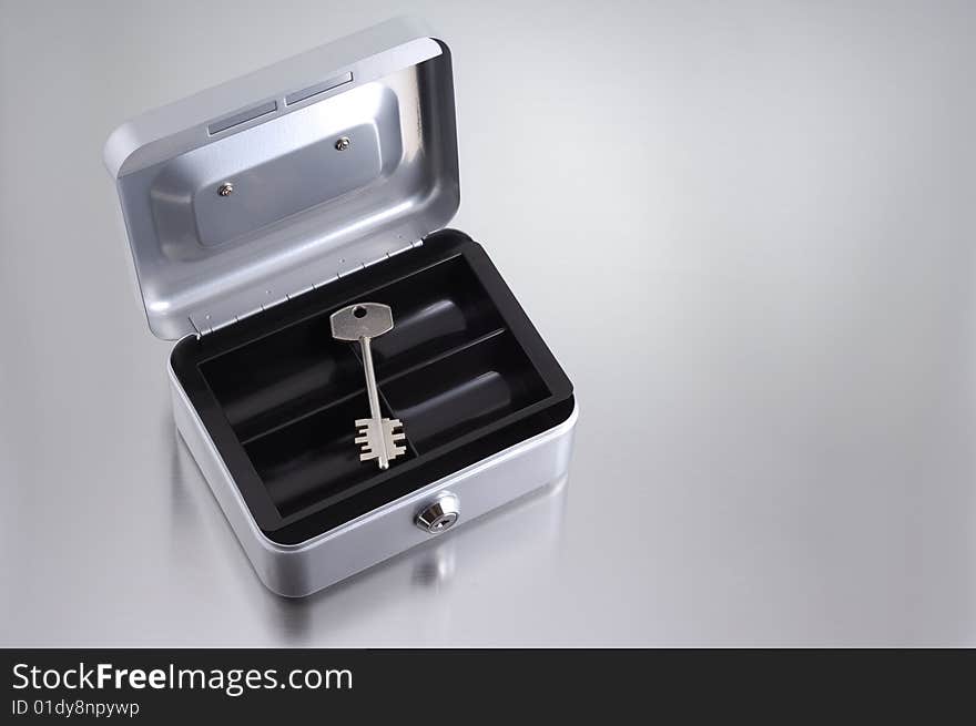 Metal key inside metallic box. Metal key inside metallic box