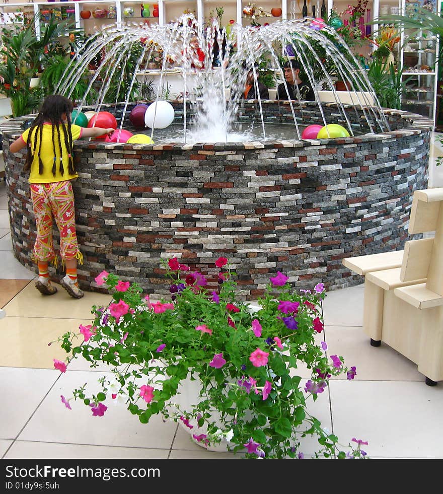 The girl and the jolly fountain with colorful airy balls. The girl and the jolly fountain with colorful airy balls