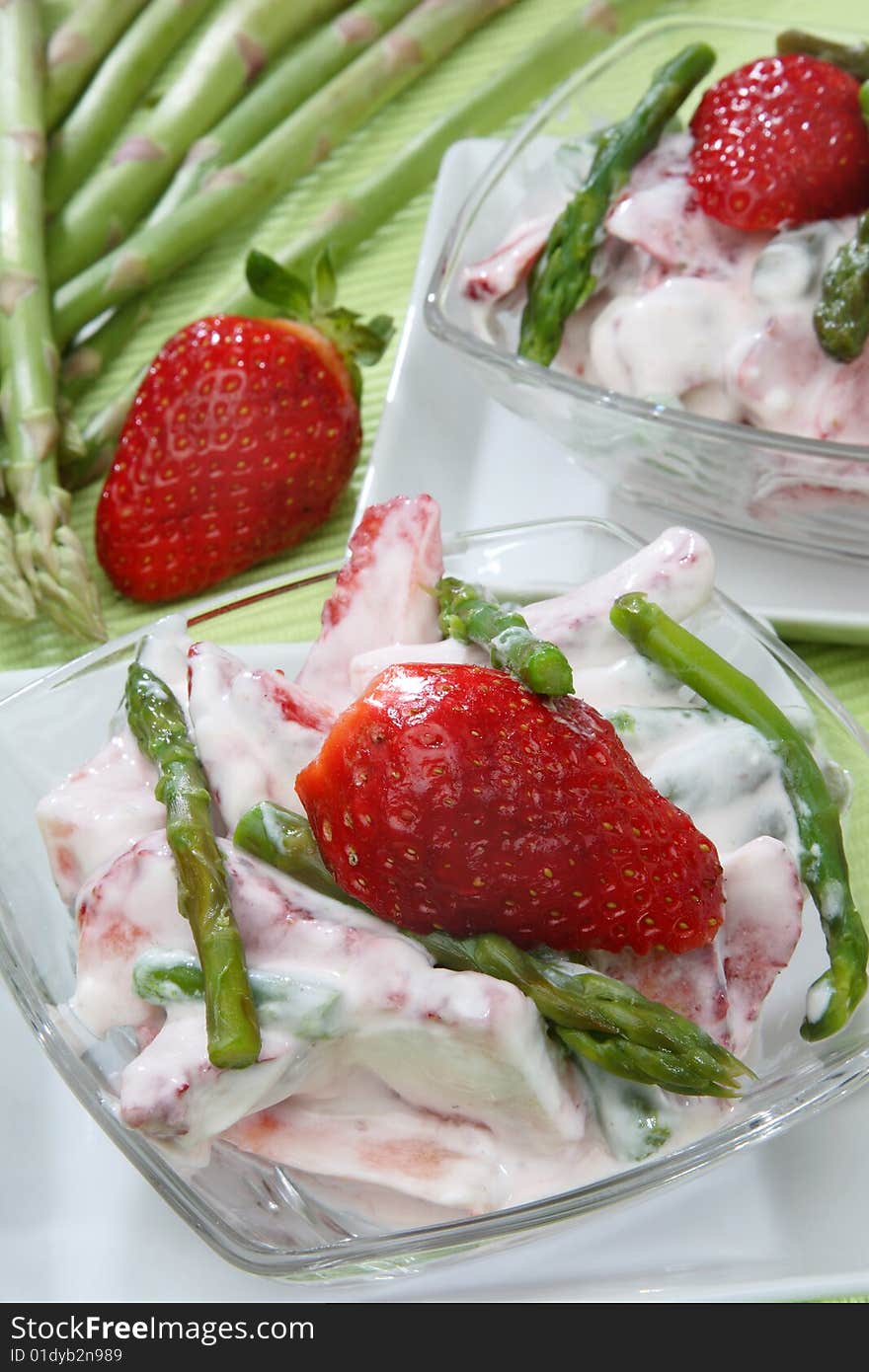 Fresh strawberries in white cream with green aspar