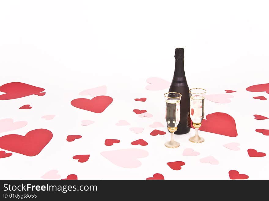 Two glasses  of white wine on white heart covered background