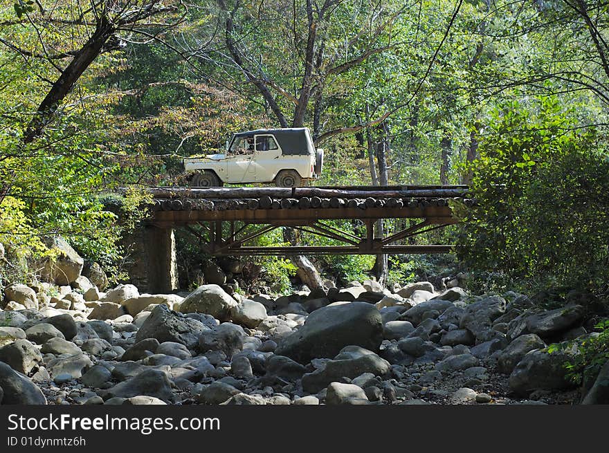 Car crossing the bridge in the summer forest. Car crossing the bridge in the summer forest.