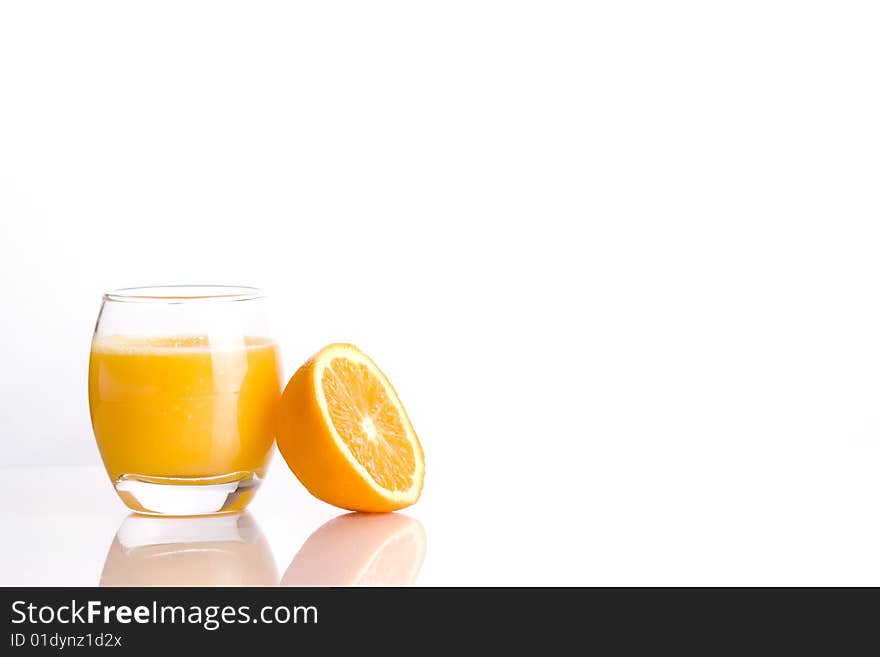 Composition of a glass with a refreshing orange´s juice and the half of a orange. Composition of a glass with a refreshing orange´s juice and the half of a orange