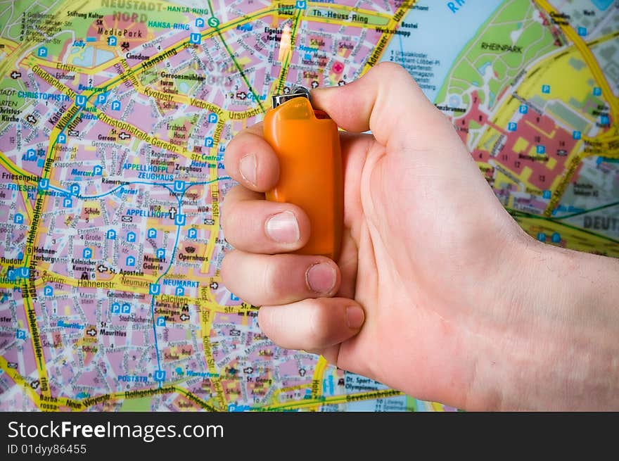 Hand with lighter over blurred map. Hand with lighter over blurred map