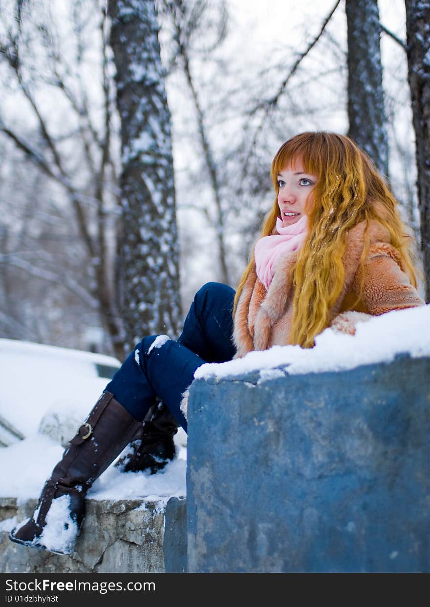 Red-heared girl in short fur coat outdoors - shallow DOF. Red-heared girl in short fur coat outdoors - shallow DOF