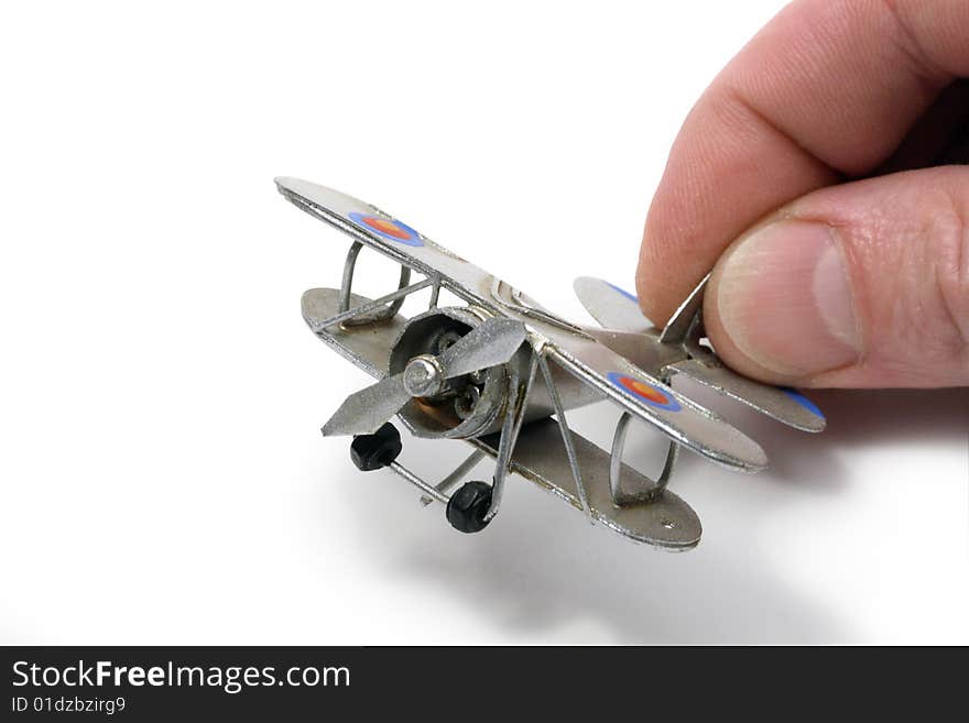 Isolated man hand holding a small model of silver ancient plane. Isolated man hand holding a small model of silver ancient plane