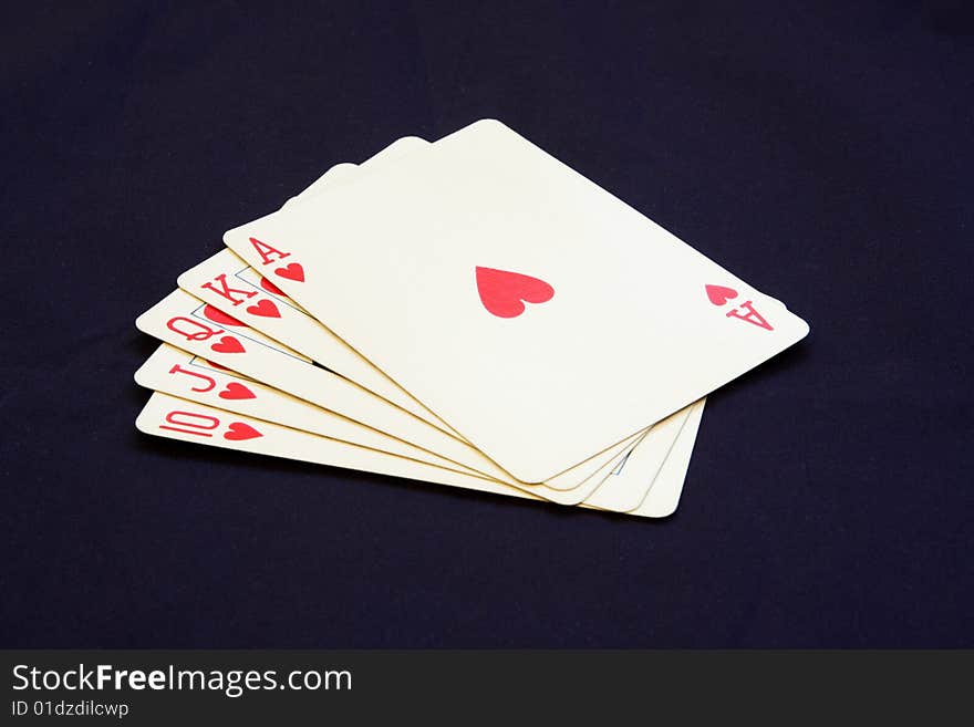 Royal flush poker hand showing hearts on a black background. Royal flush poker hand showing hearts on a black background