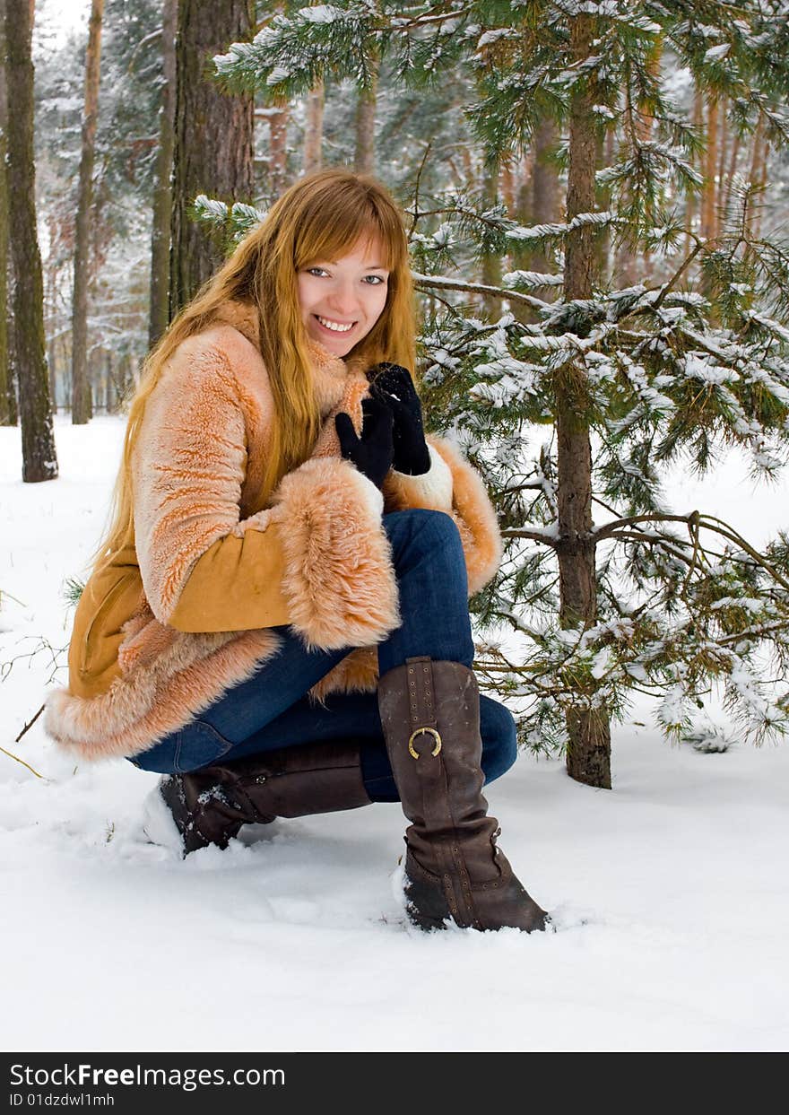 Red-heared girl in short fur coat outdoors. Red-heared girl in short fur coat outdoors