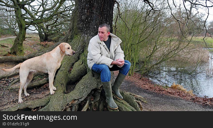 Man and yellow labrador puppy in the forest. Man and yellow labrador puppy in the forest