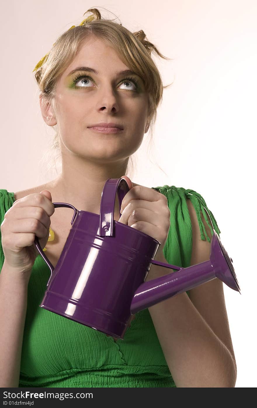 Woman keeps purple watering can. Woman keeps purple watering can