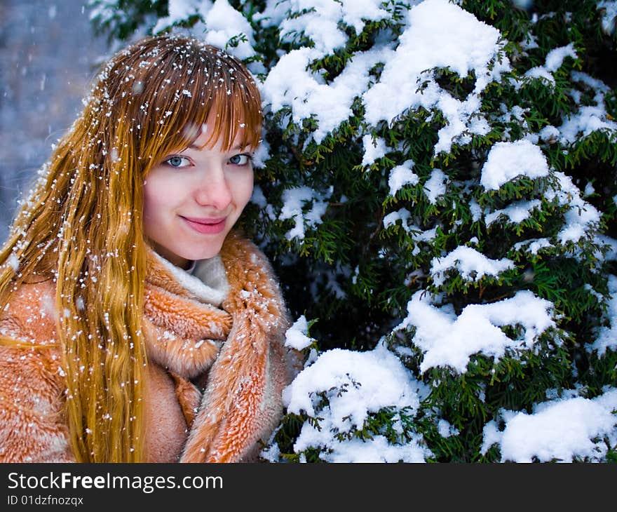 Red-heared girl in fur coat outdoors - shallow DOF. Red-heared girl in fur coat outdoors - shallow DOF