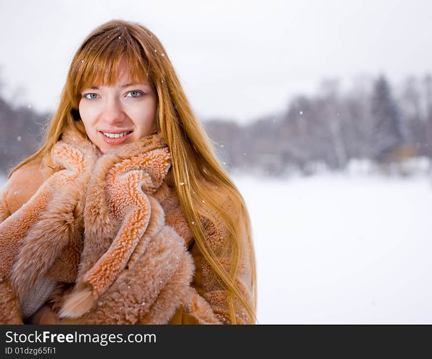 Red-heared girl in fur coat outdoors - shallow DOF. Red-heared girl in fur coat outdoors - shallow DOF