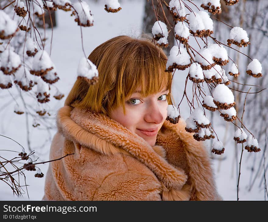 Red-heared girl in fur coat outdoors - shallow DOF. Red-heared girl in fur coat outdoors - shallow DOF