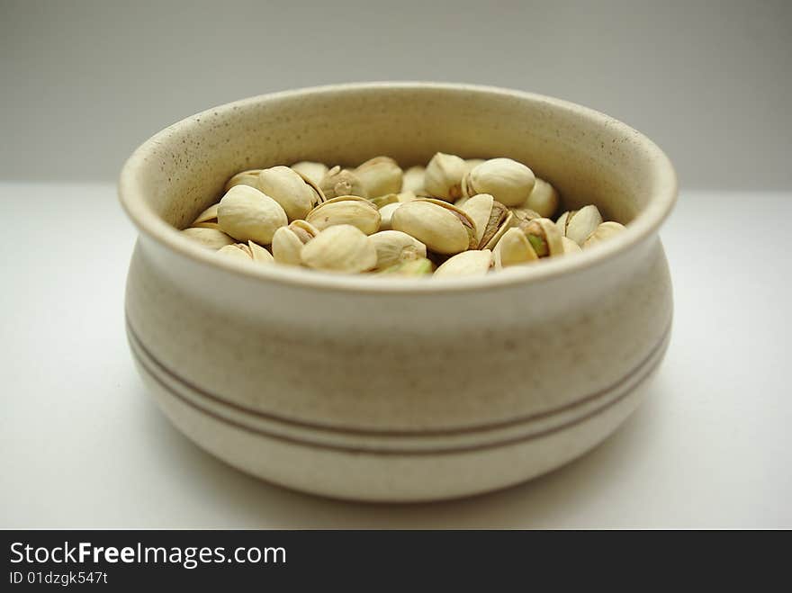 Pistachio quotations in ceramic saucer, ready to food. Pistachio quotations in ceramic saucer, ready to food.