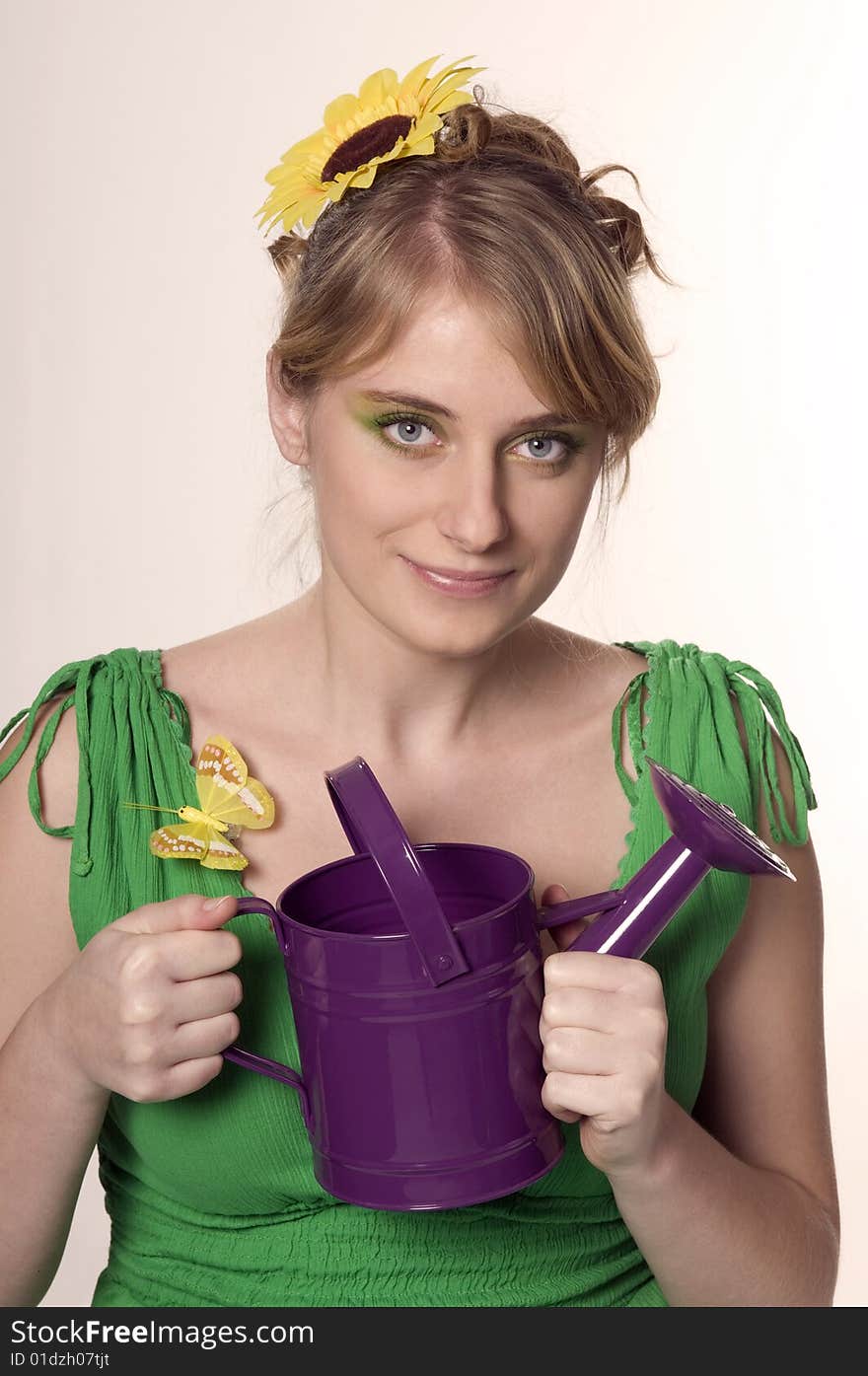 Woman keeps purple watering can. Woman keeps purple watering can