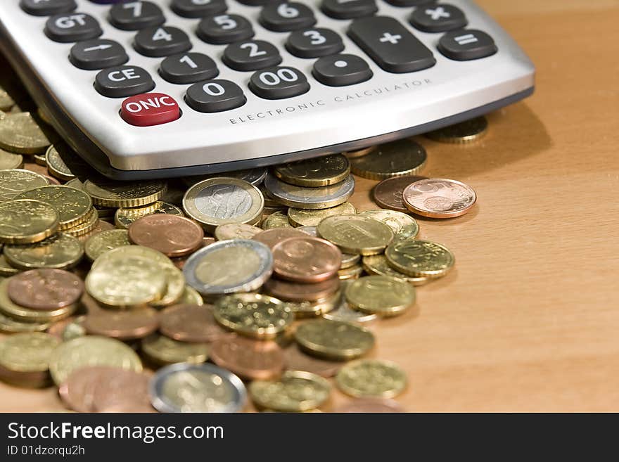 Pocket calculator and euro coins on table