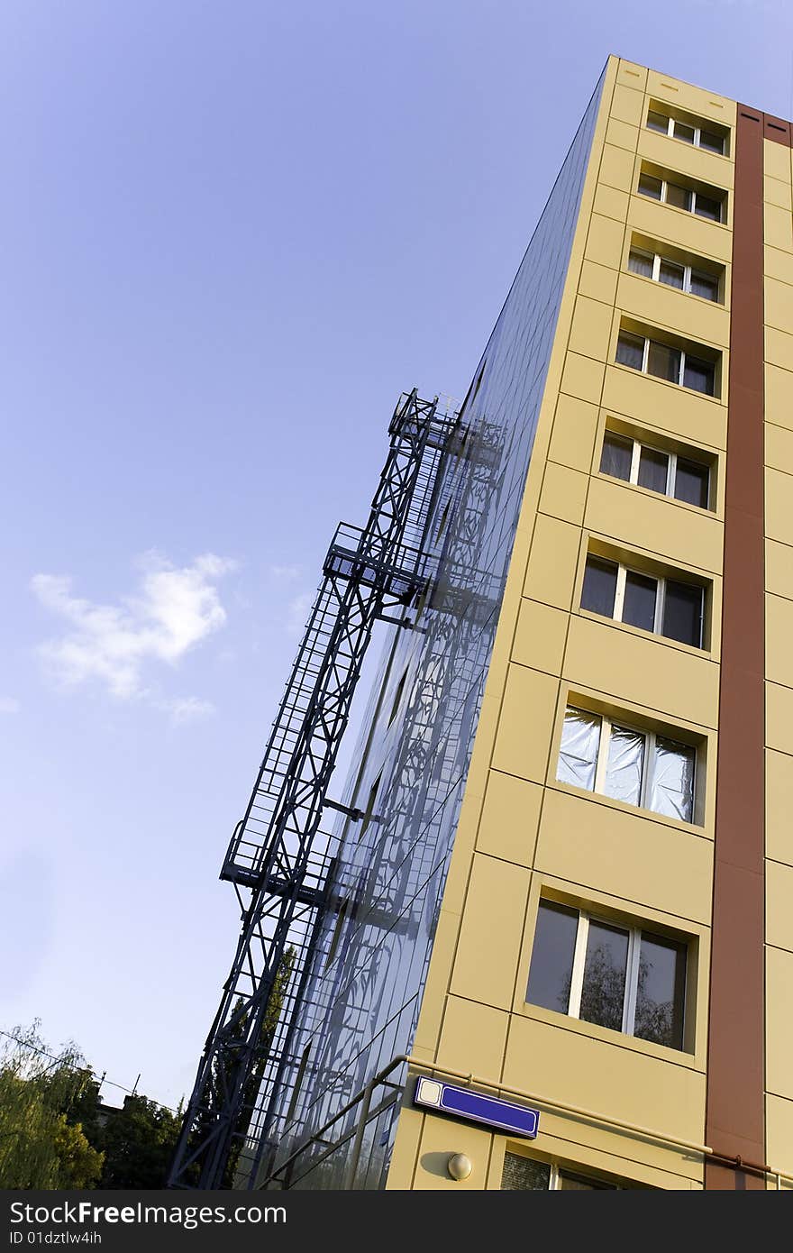 A background of a modern building in yellow and brown color, with furnishings of aluminum for windows. A background of a modern building in yellow and brown color, with furnishings of aluminum for windows.