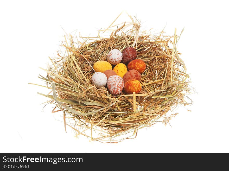 Miniature Easter eggs in a straw nest. Miniature Easter eggs in a straw nest