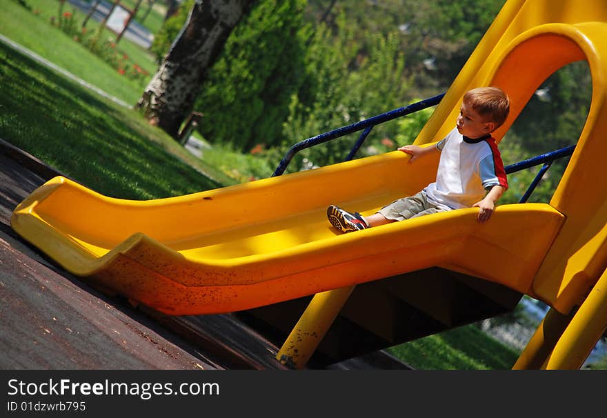 Boy on a yellow slide. Boy on a yellow slide