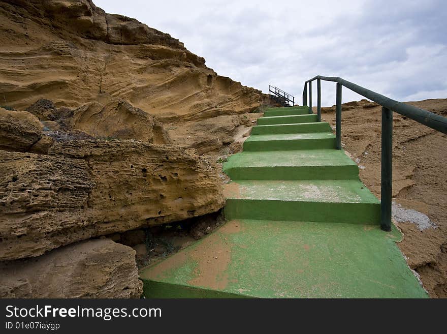 A green staircase between the rocks a winter day near the sea