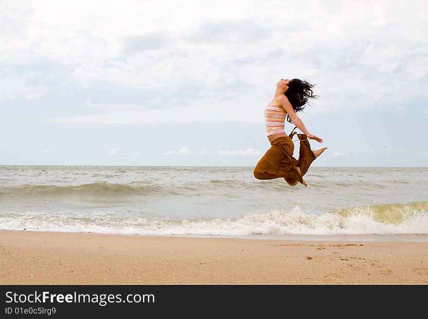 Happy woman is jumping in beach