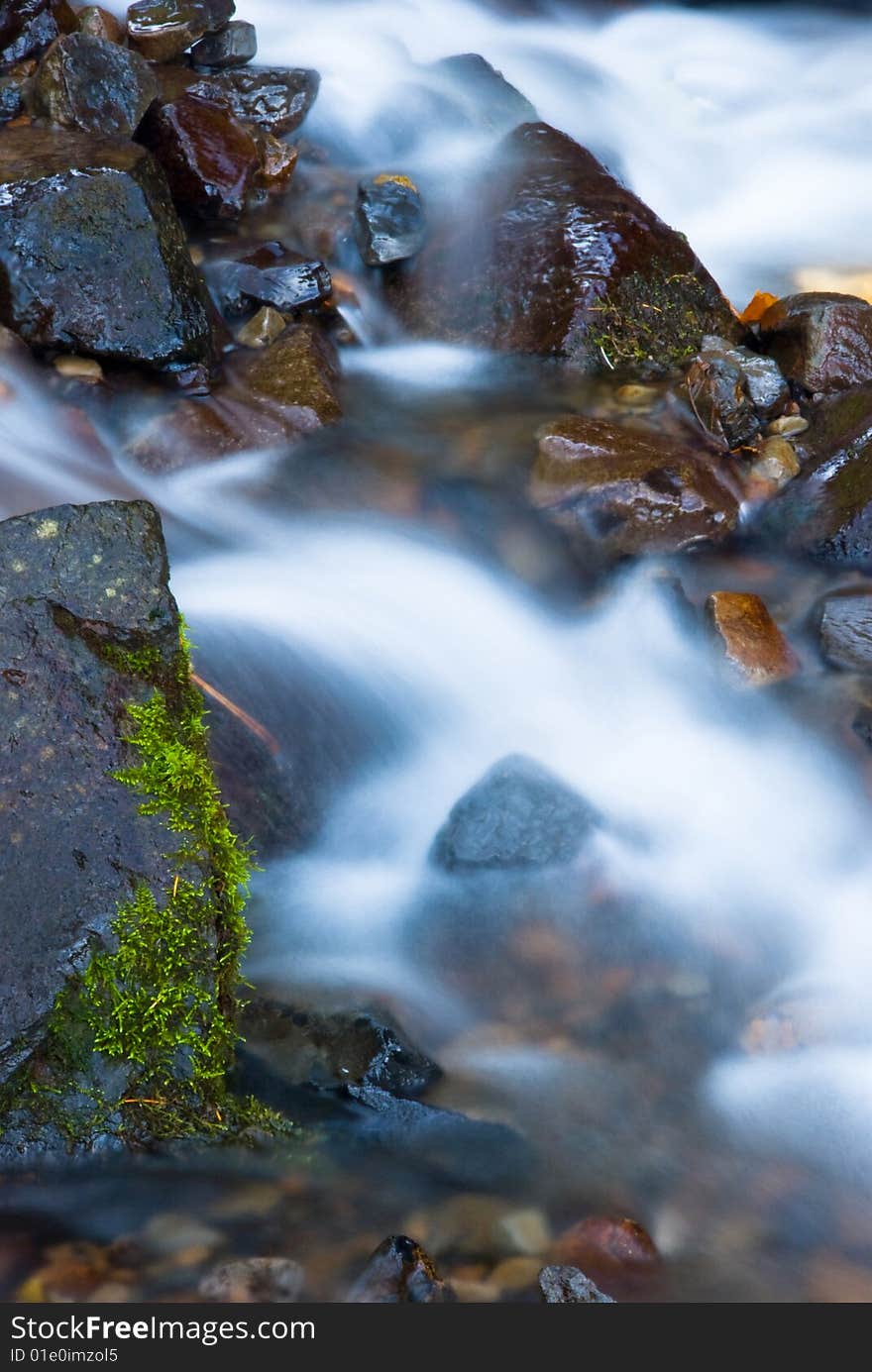 A motion blur shot of water flowing rapidly down a stream. A motion blur shot of water flowing rapidly down a stream.