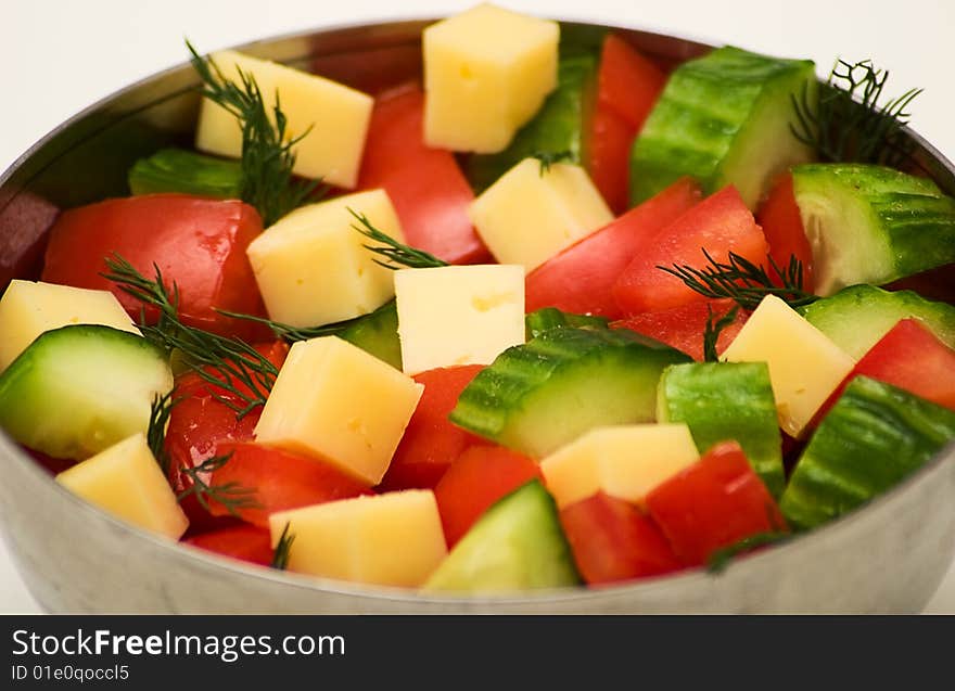 Tomatoes, cucumbers, dill and cheese in the iron bowl. Isolated on a white background. Studio light. Tomatoes, cucumbers, dill and cheese in the iron bowl. Isolated on a white background. Studio light.