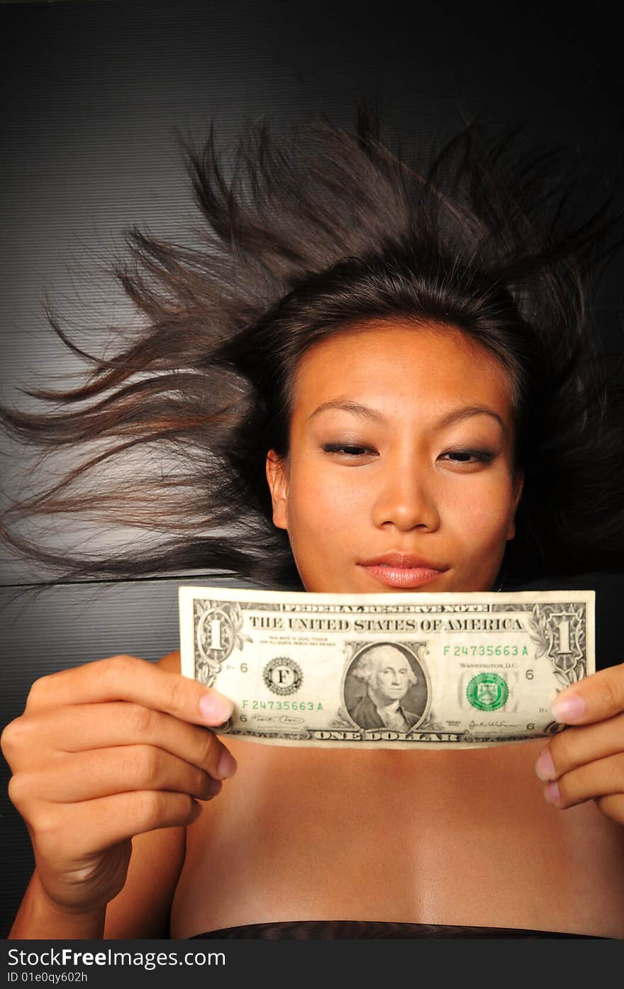 Chinese Asian Woman looking at Dollar bill