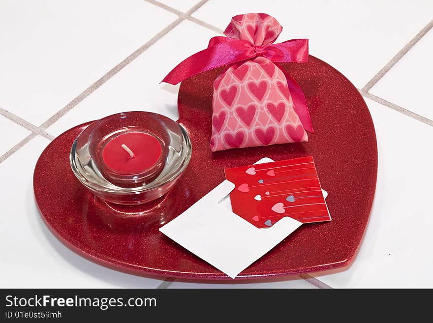 Red metallic heart dish with red candle in holder and valentine sachet with card. Red metallic heart dish with red candle in holder and valentine sachet with card