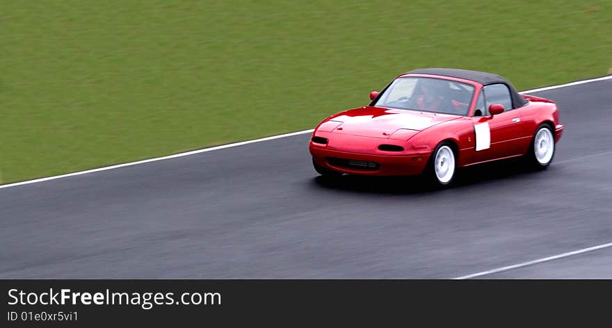 A Sports Car going down the straight.