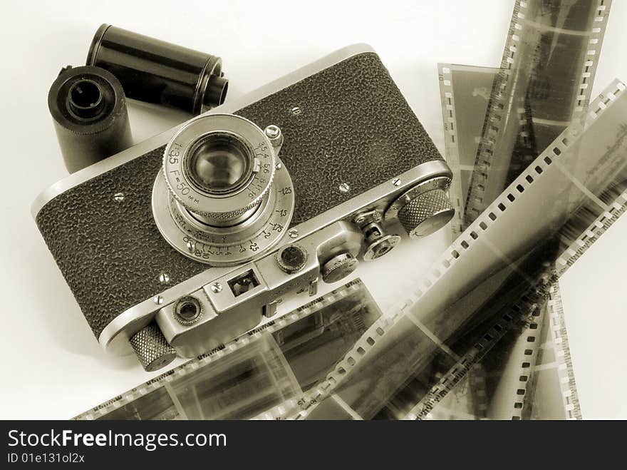 The old film camera with cartridges and strips of a negative film. The old film camera with cartridges and strips of a negative film.