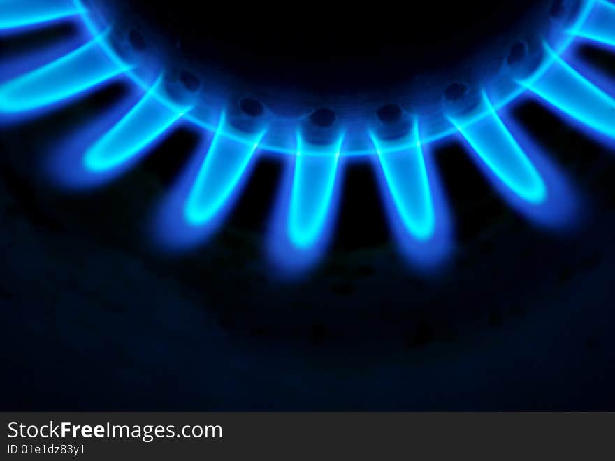 Blue flames of gas stove in the dark