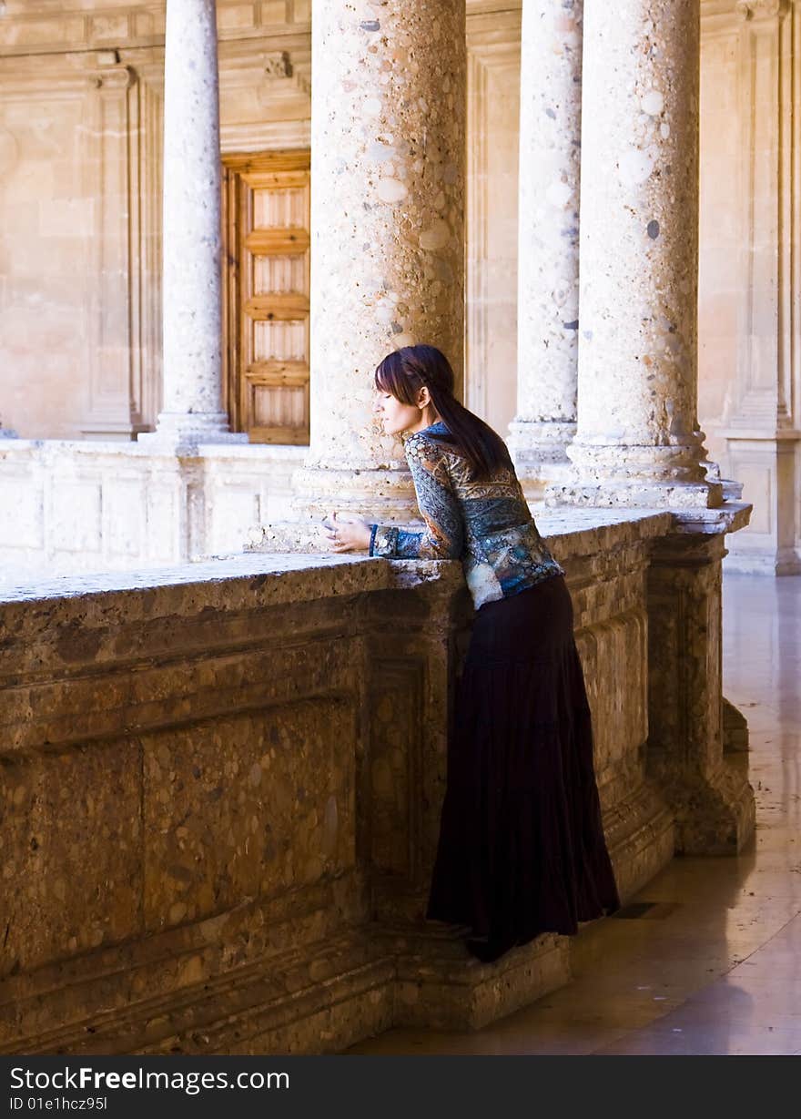 Young woman posing in old palace column. Young woman posing in old palace column.