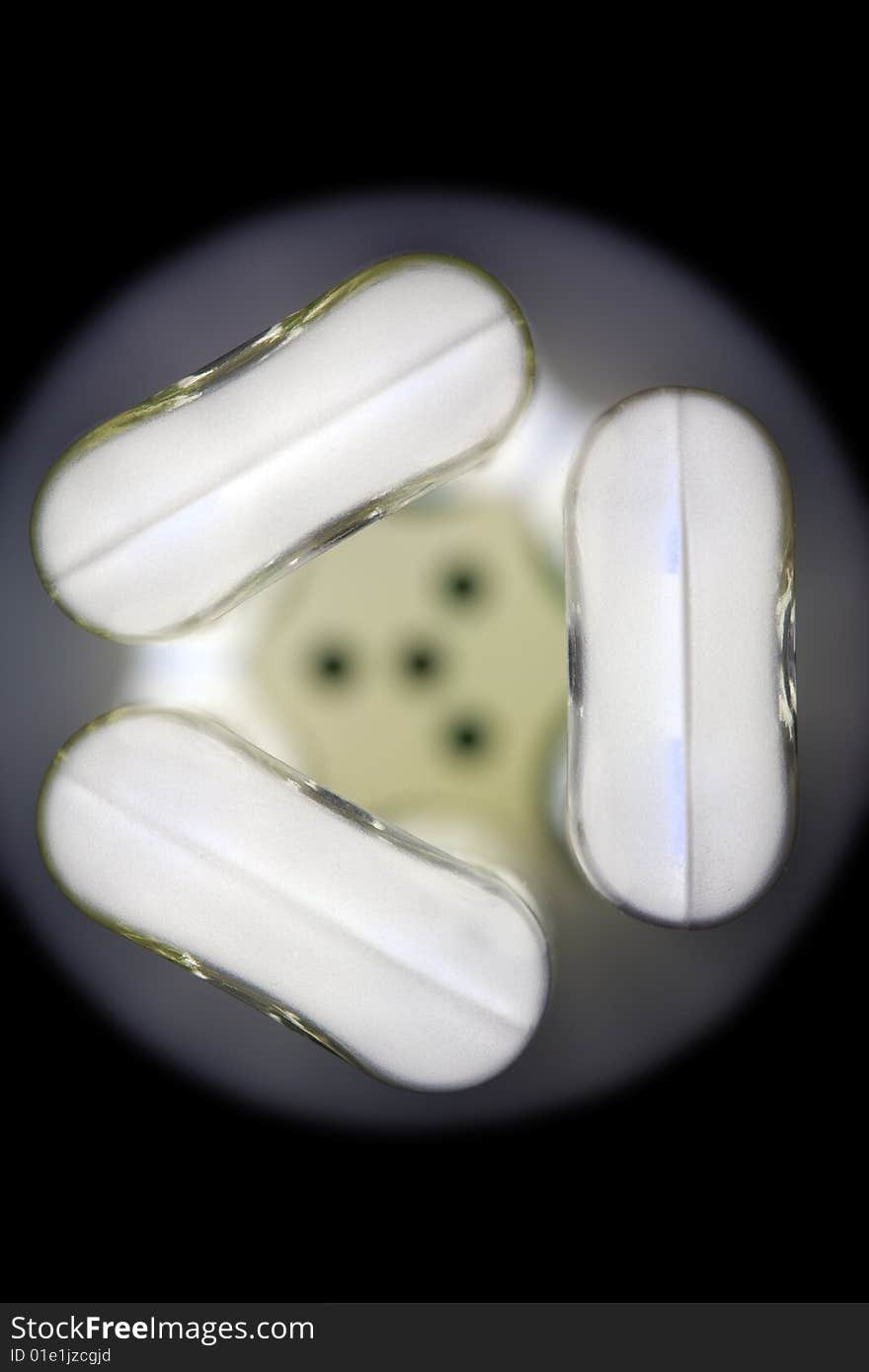 Close-up of the tip of a lit energy-saving light bulb, slightly abstract due to selective focus, against black background. Close-up of the tip of a lit energy-saving light bulb, slightly abstract due to selective focus, against black background