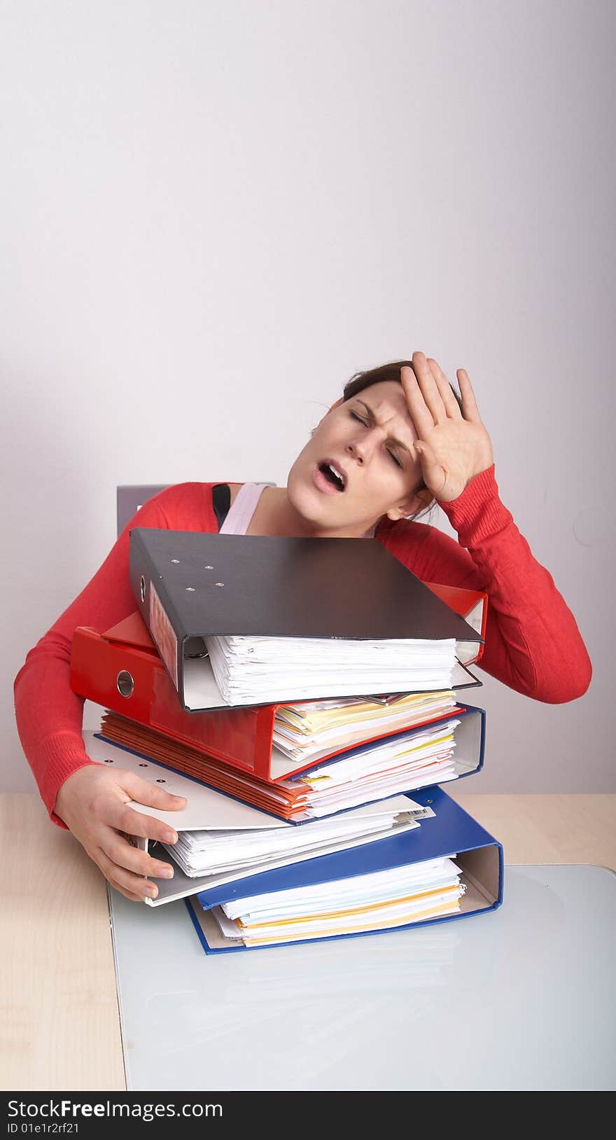 A young and beautiful female student is stressed with a lot of paperwork in front of her. A lot of copyspace. A young and beautiful female student is stressed with a lot of paperwork in front of her. A lot of copyspace.