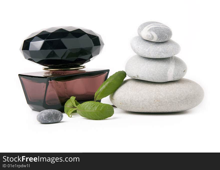 Perfume, stones and green leafs