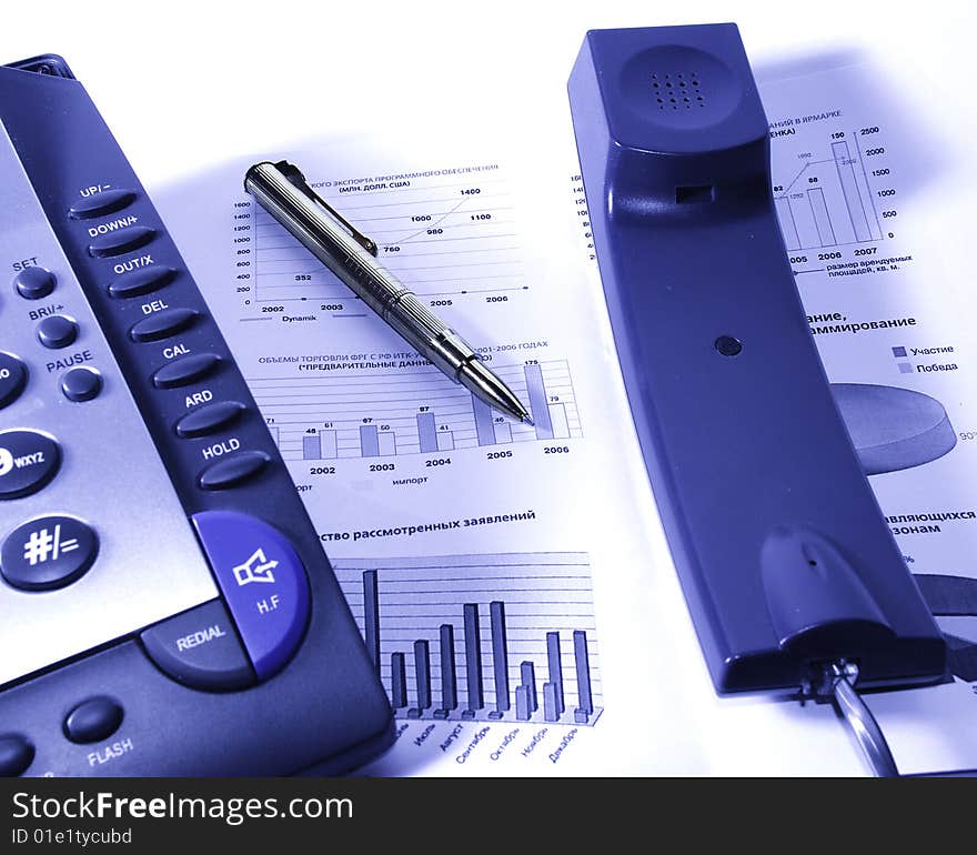 Phone; fountain pen; glasses and stock chart. Phone; fountain pen; glasses and stock chart