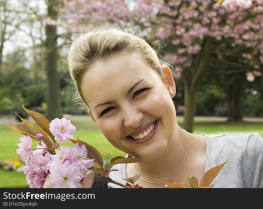 Smiling young women with cherry blossoms in the park. Smiling young women with cherry blossoms in the park