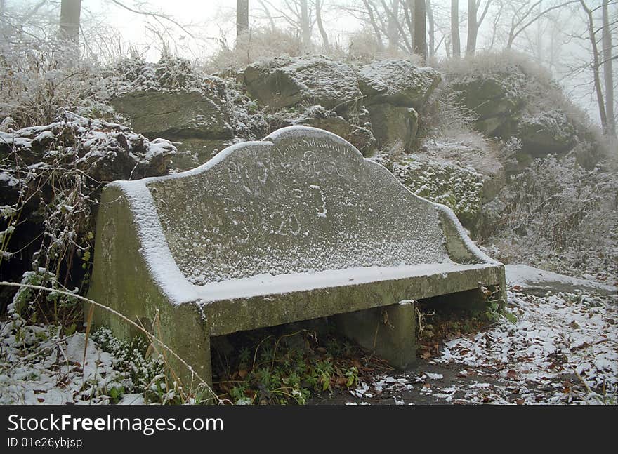 Stone bench in a park - winter time.