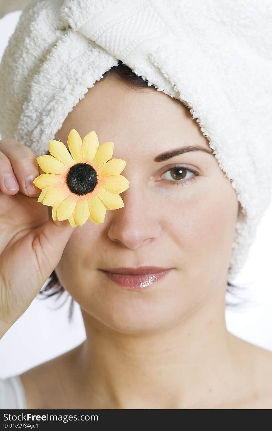 Beautiful young woman with towel and flower