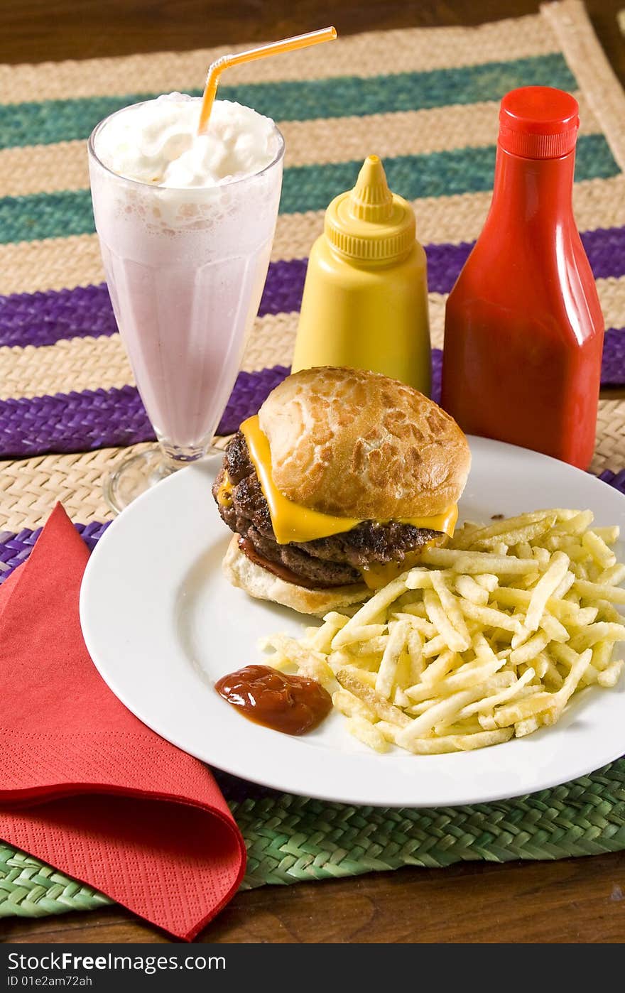 Cheeseburger with fries and strawberry milkshake. Cheeseburger with fries and strawberry milkshake