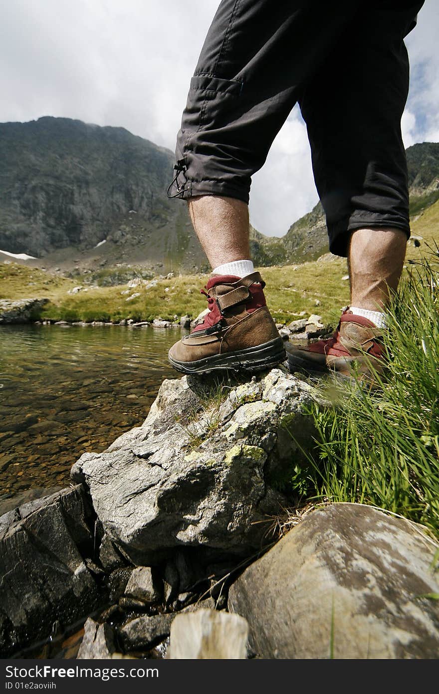 Shoes of a hiker on a hike in the mountains near a lake. Shoes of a hiker on a hike in the mountains near a lake